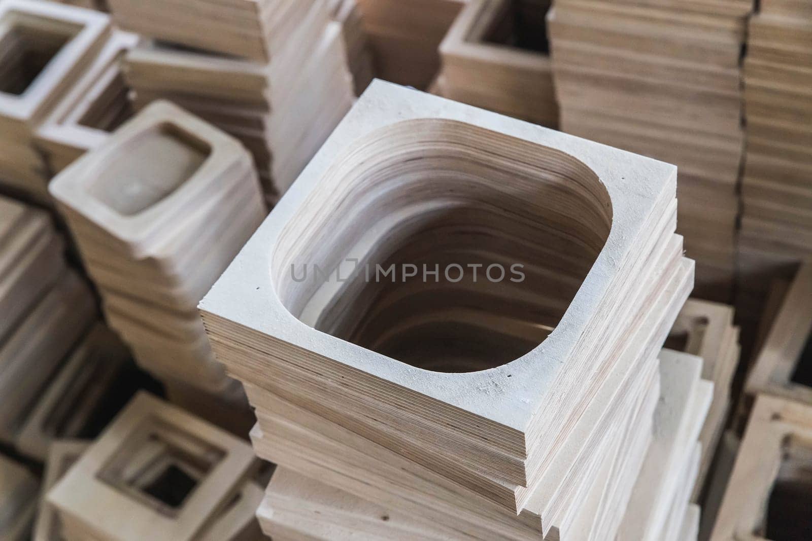 A stack of plywood frames are in the workshop foreground focus.
