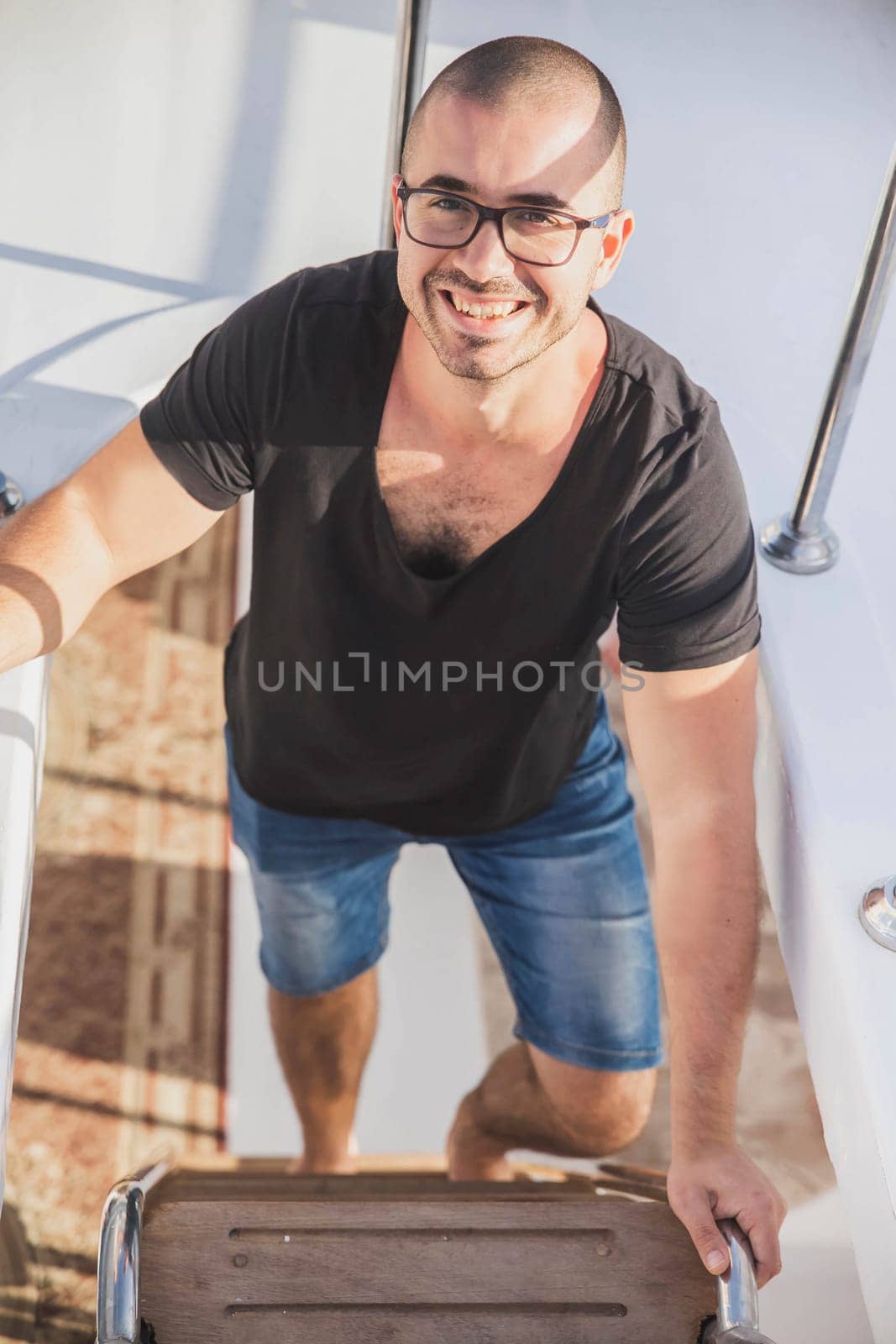 attractive guy climbs the stairs on the yacht.