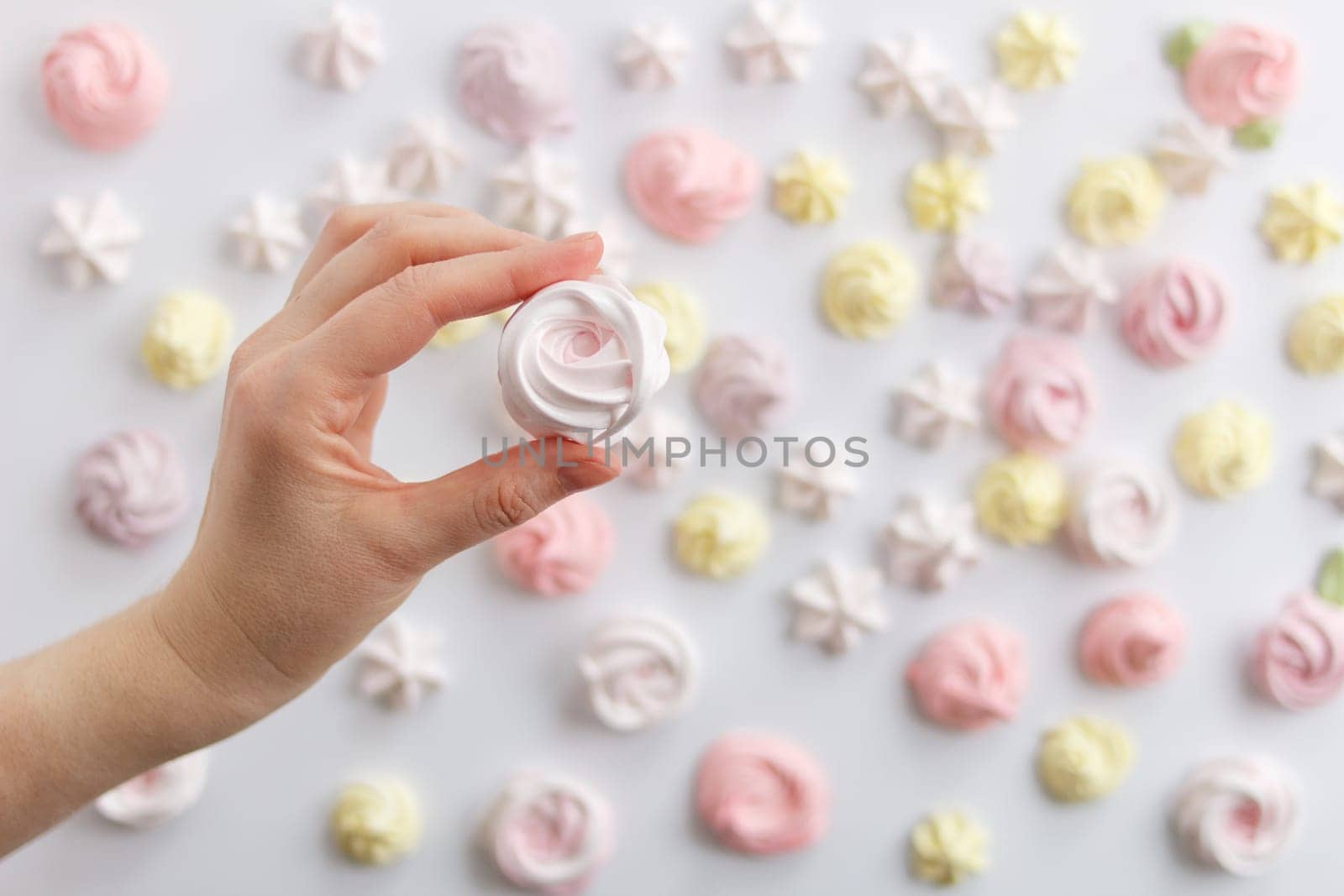 Meringue. Light dessert of whipped egg whites in a female hand . by lara29