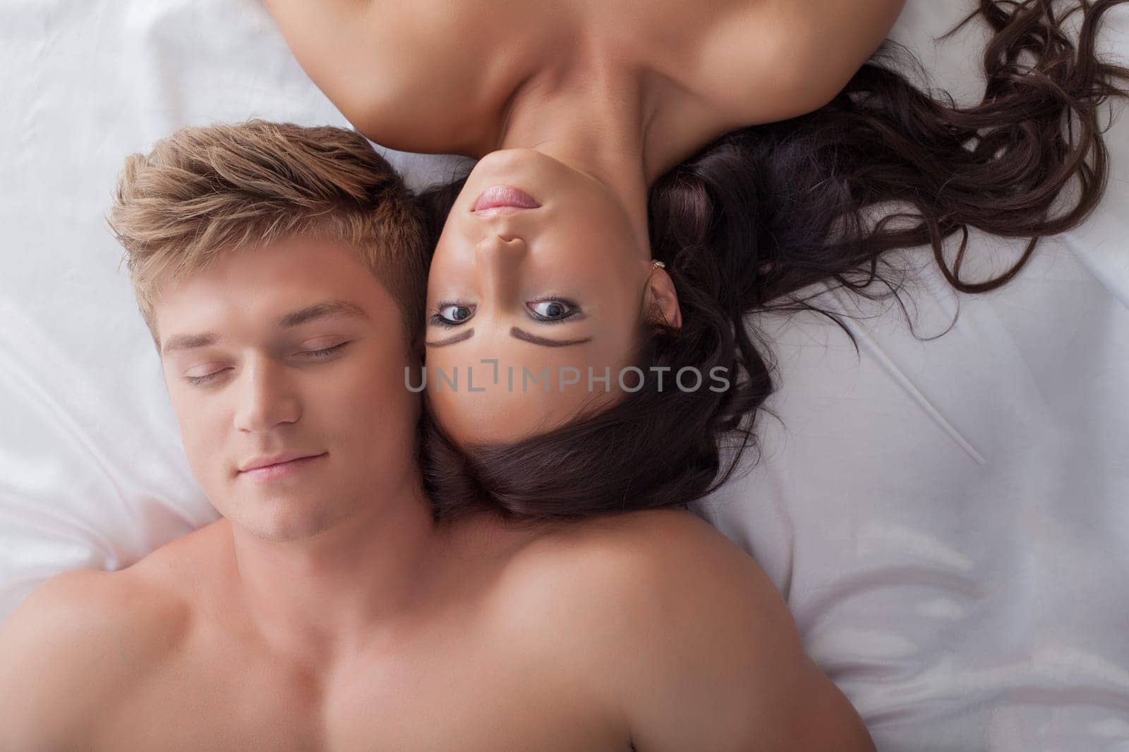 Image of beautiful young heterosexual couple in bed, close-up