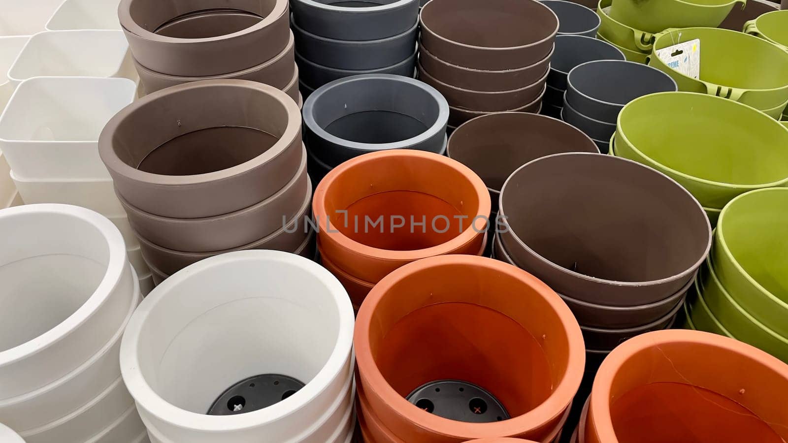 Close-up of empty flower pots in a store or greenhouse. Colorful pots for plants. Gardening and landscape design concept by Matiunina