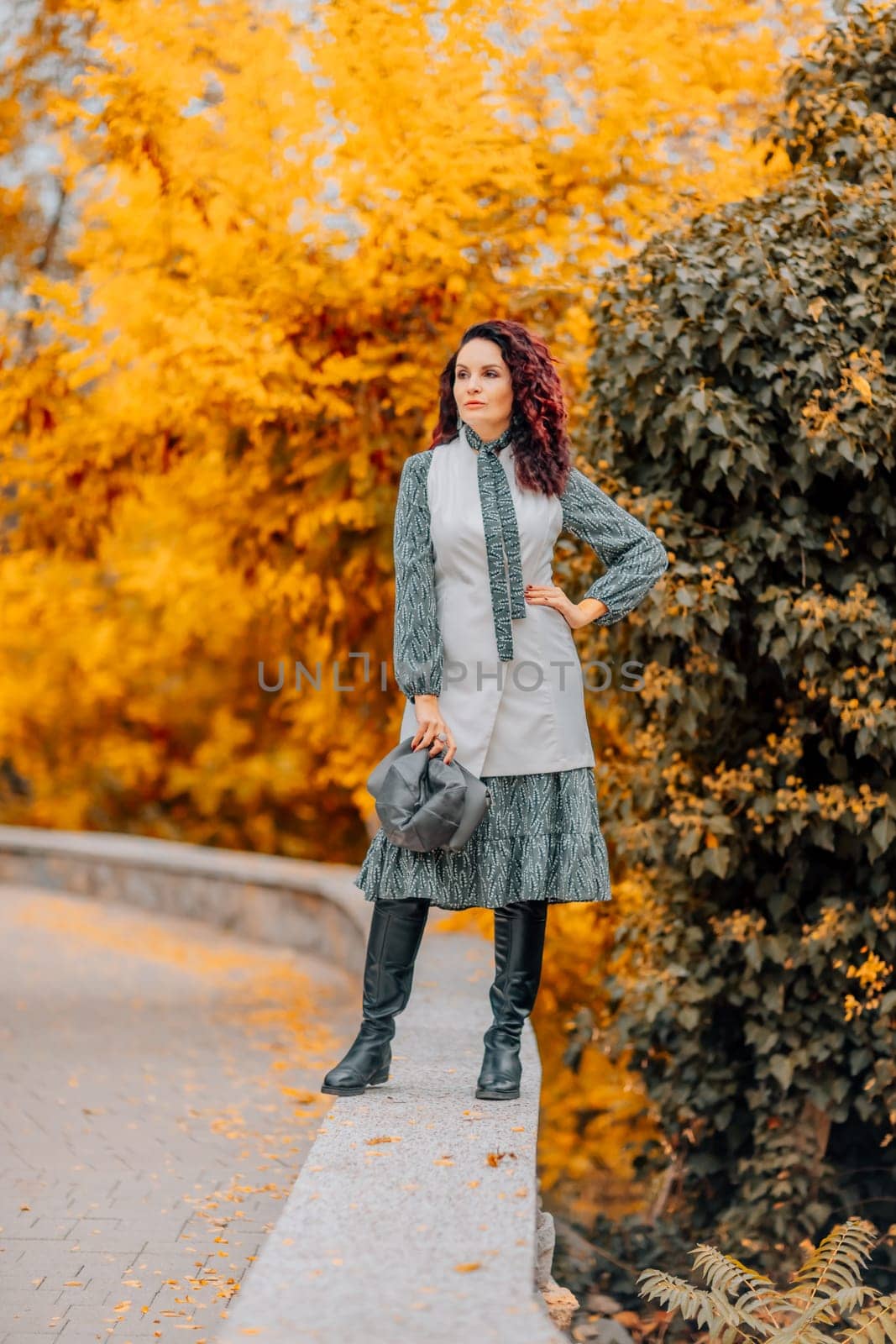 A woman walks outdoors in autumn, enjoys the autumn weather. by Matiunina