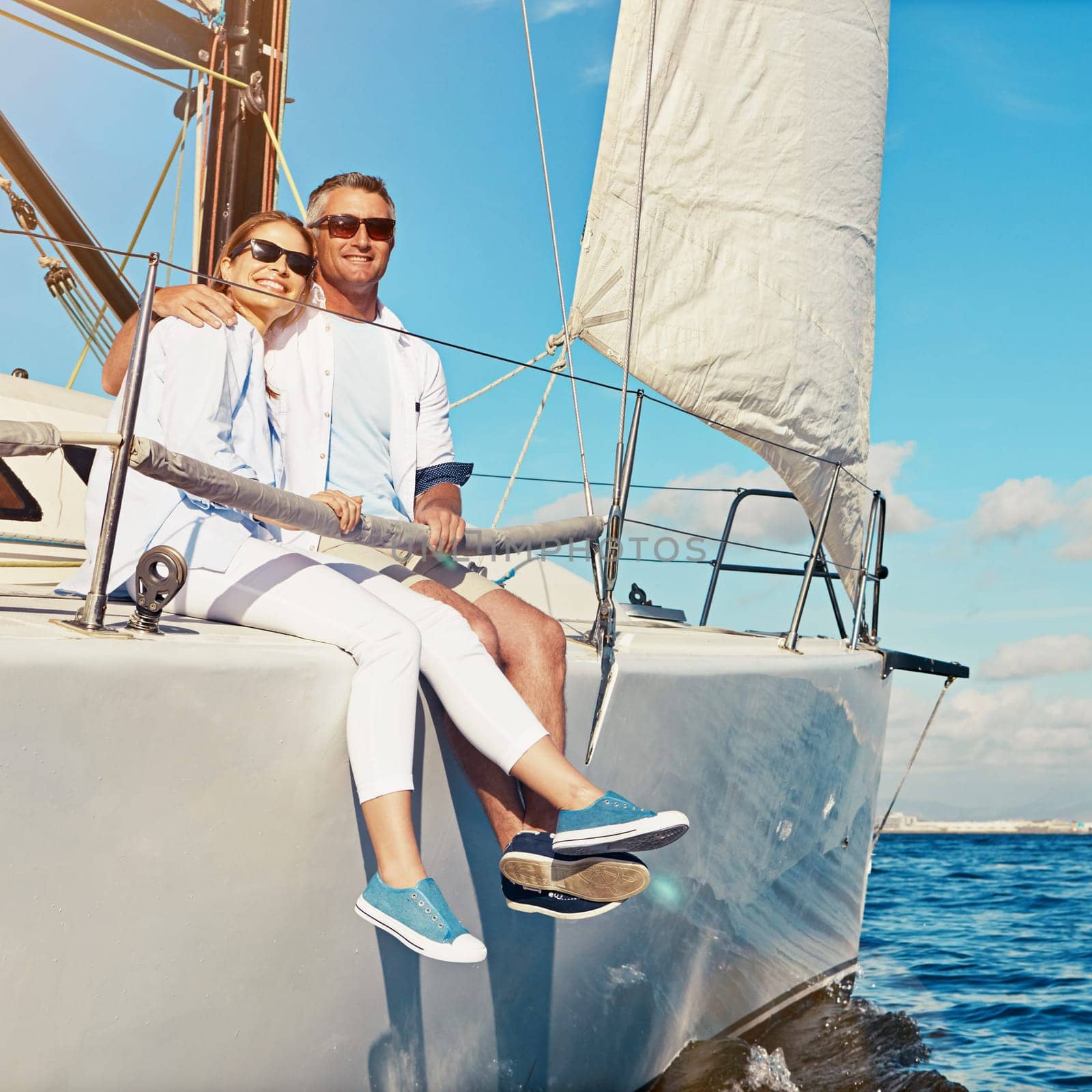 Lets stick together as long as we love and travel. a couple enjoying a boat cruise out on the ocean. by YuriArcurs