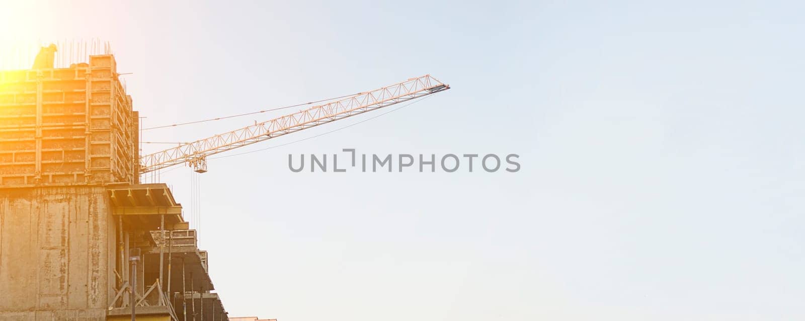 Construction site and construction crane on sunset.Banner,copyspace.