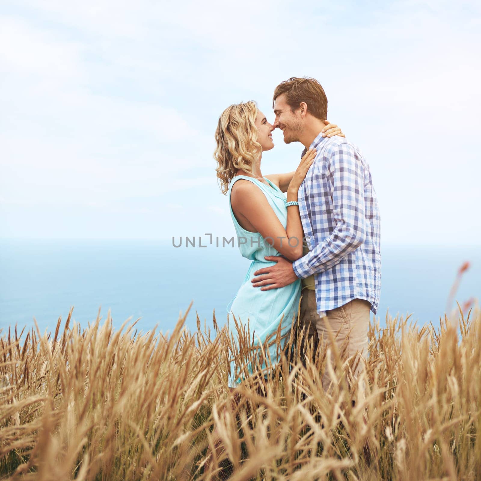 The moment before a kiss. a young couple in a field on a sunny day