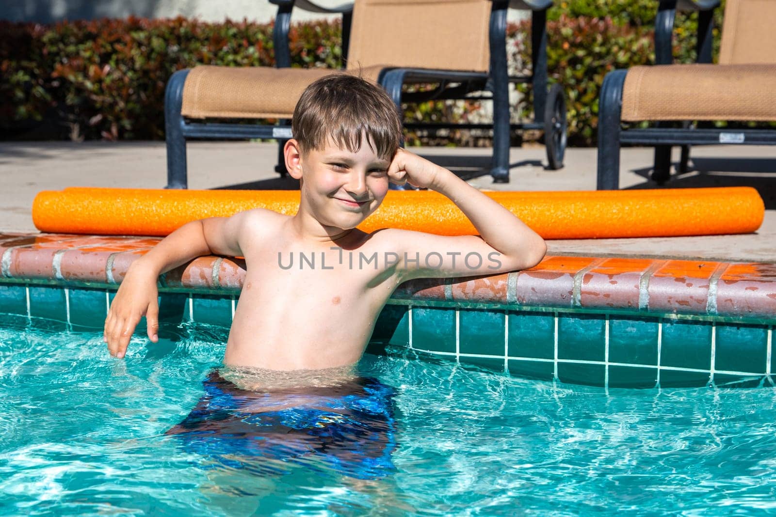Oudoor summer activity. Concept of fun, health and vacation. Boy eight years old sits in a pool in hot summer day. by Marina-A