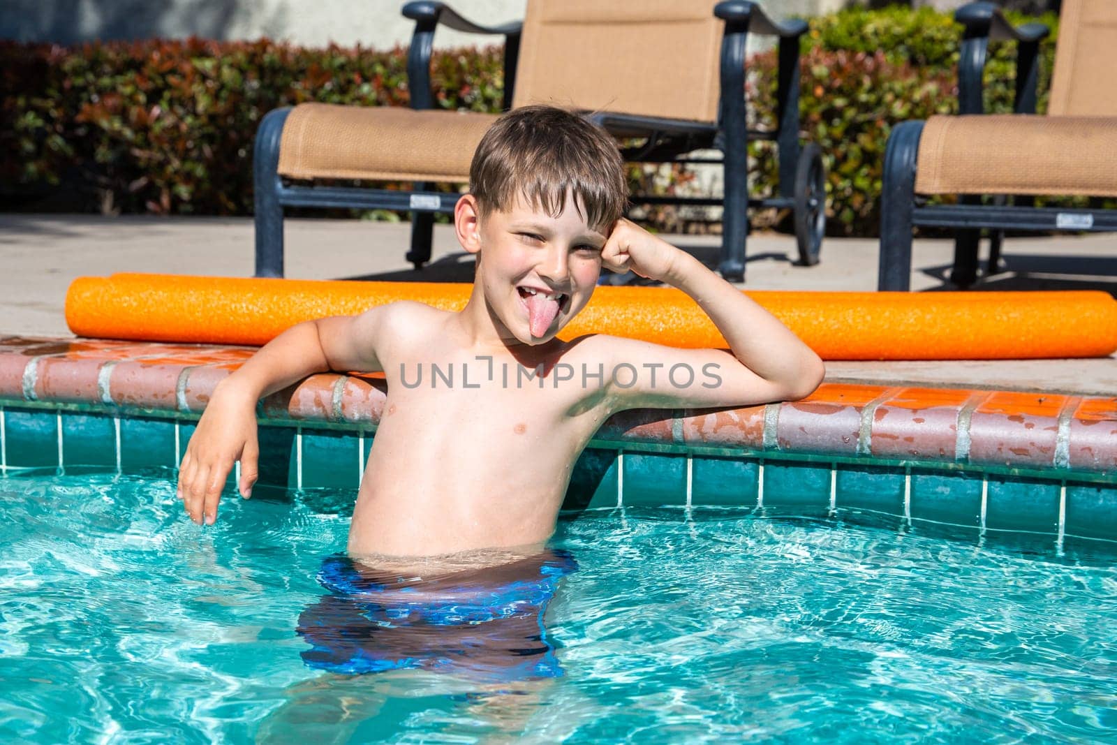 Oudoor summer activity. Concept of fun, health and vacation. Boy eight years old sits in a pool in hot summer day. by Marina-A