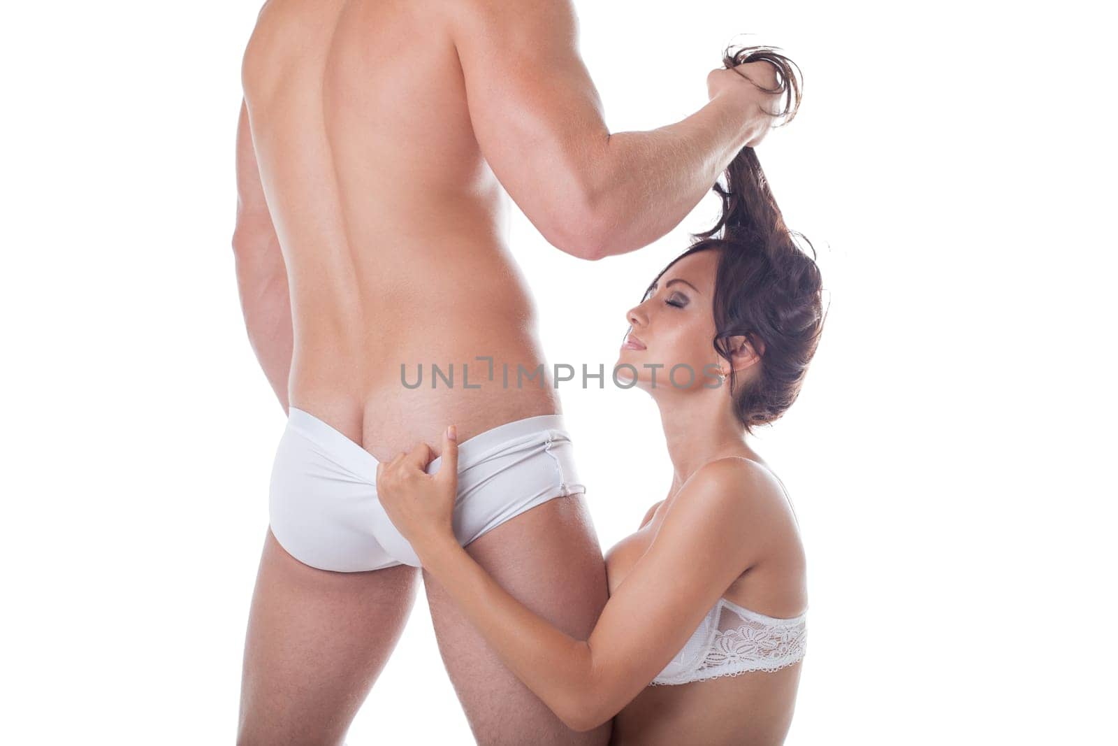 Muscular man and sexy girl kneeling before him, close-up