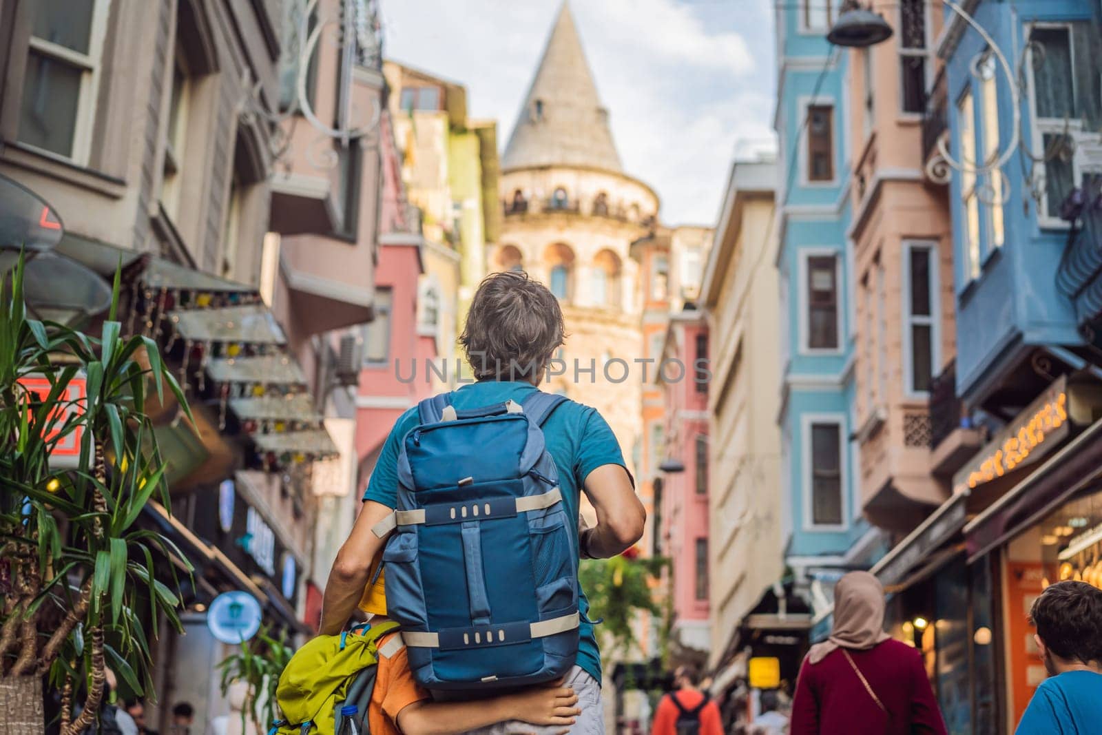 Portrait of father and son tourists with view of Galata tower in Beyoglu, Istanbul, Turkey. Turkiye. Traveling with kids concept.