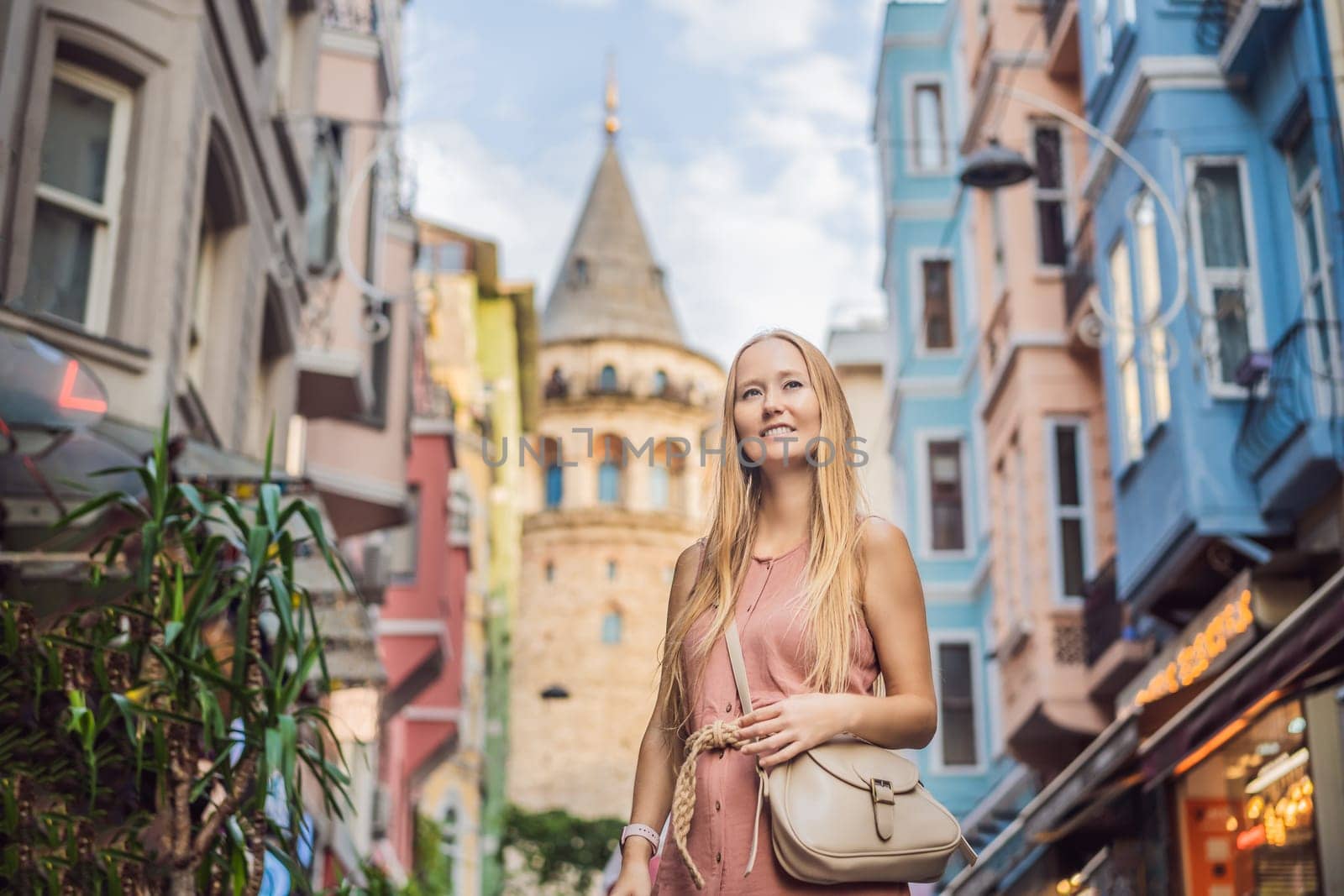 Portrait of beautiful woman tourist with view of Galata tower in Beyoglu, Istanbul, Turkey. Turkiye.