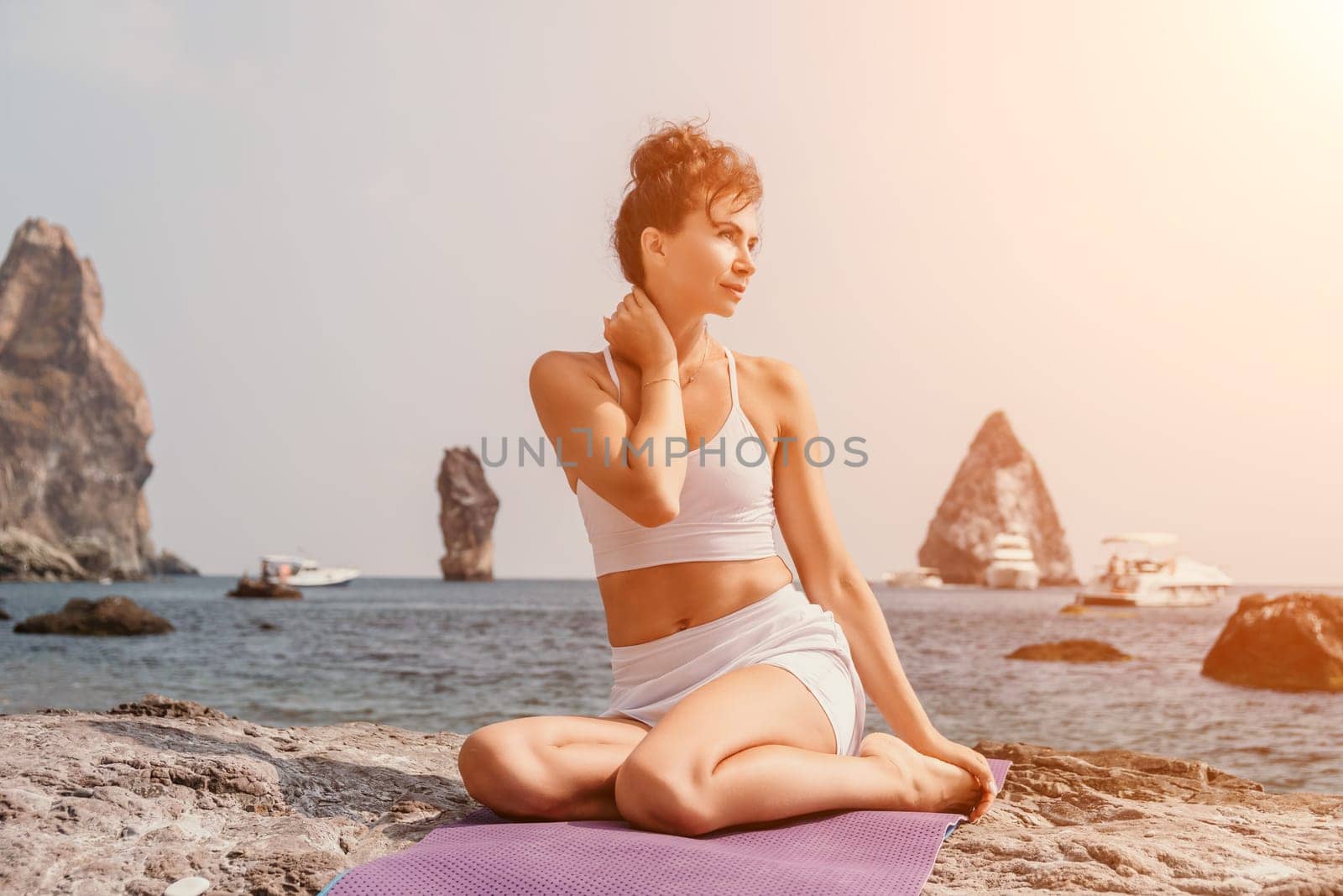 Fitness woman sea. Outdoor workout on yoga mat in park near to ocean beach. Female fitness pilates yoga routine concept. Healthy lifestyle. Happy fit woman exercising with rubber band in park.