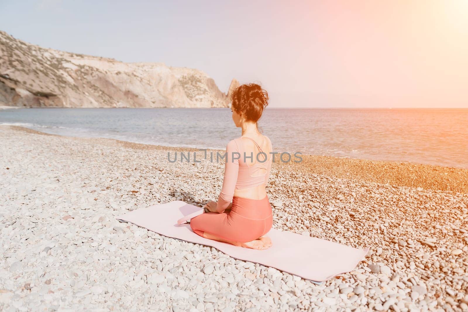 Woman sea pilates. Sporty happy middle aged woman practicing fitness on beach near sea, smiling active female training with ring on yoga mat outside, enjoying healthy lifestyle, harmony and meditation by panophotograph