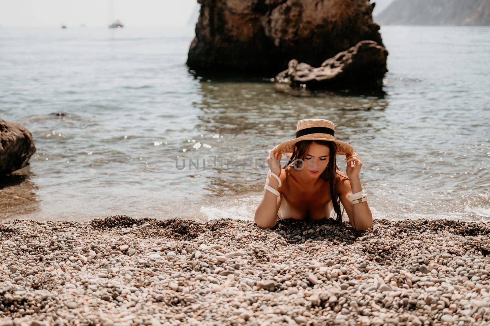 Woman travel sea. Happy tourist in hat enjoy taking picture outdoors for memories. Woman traveler posing on the beach at sea surrounded by volcanic mountains, sharing travel adventure journey by panophotograph