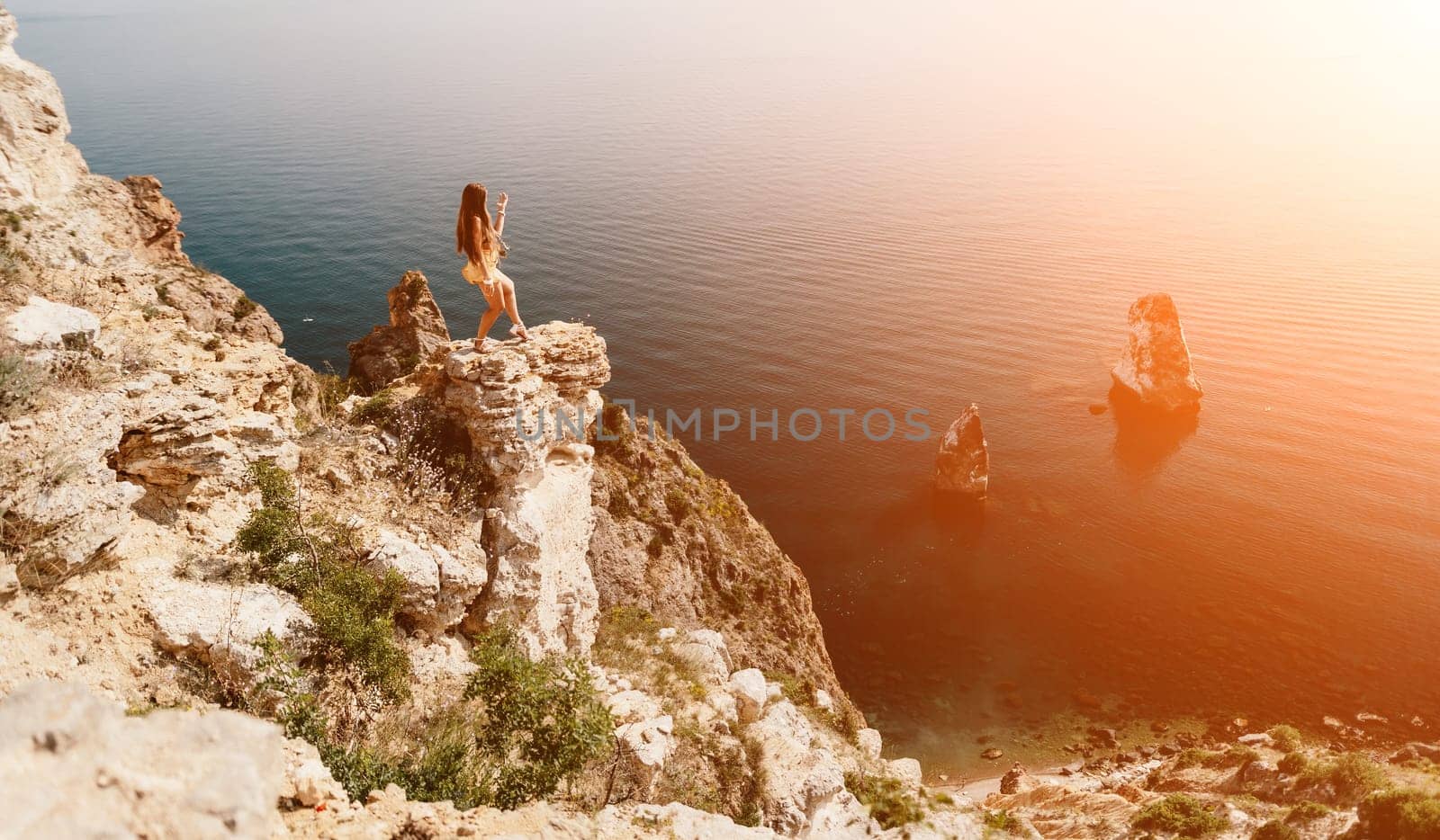 Woman travel sea. Happy tourist enjoy taking picture outdoors for memories. Woman traveler looks at the edge of the cliff on the sea bay of mountains, sharing travel adventure journey by panophotograph