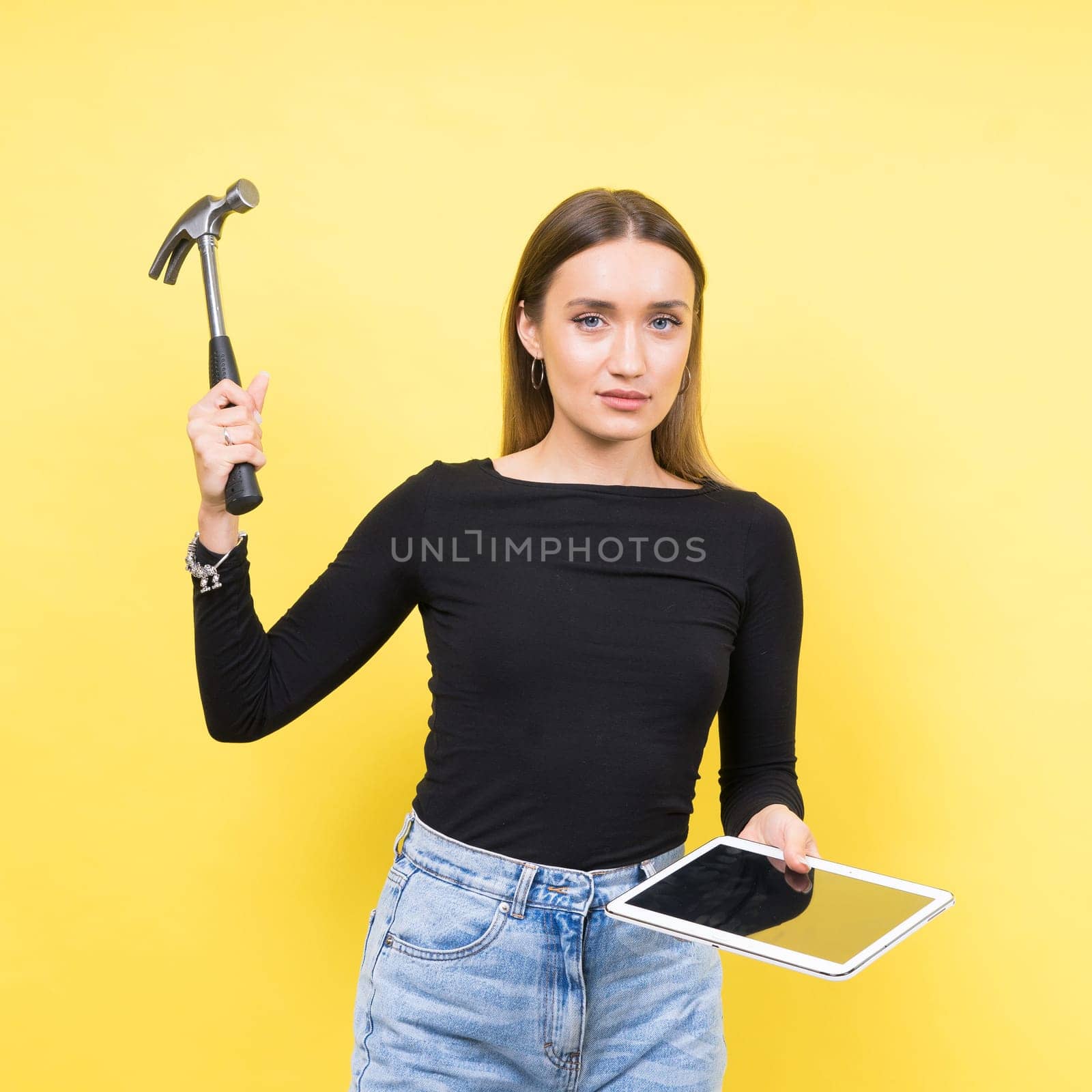 Service center. Laptop Repair. Female screwdriver unscrews laptop bolts on yellow background by Zelenin