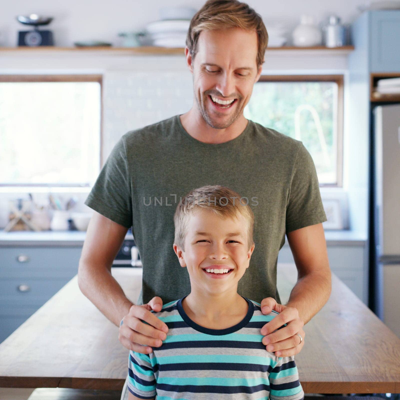 Happiness is our thing. an affectionate young father looking cheerful while standing with his son in their kitchen at home. by YuriArcurs