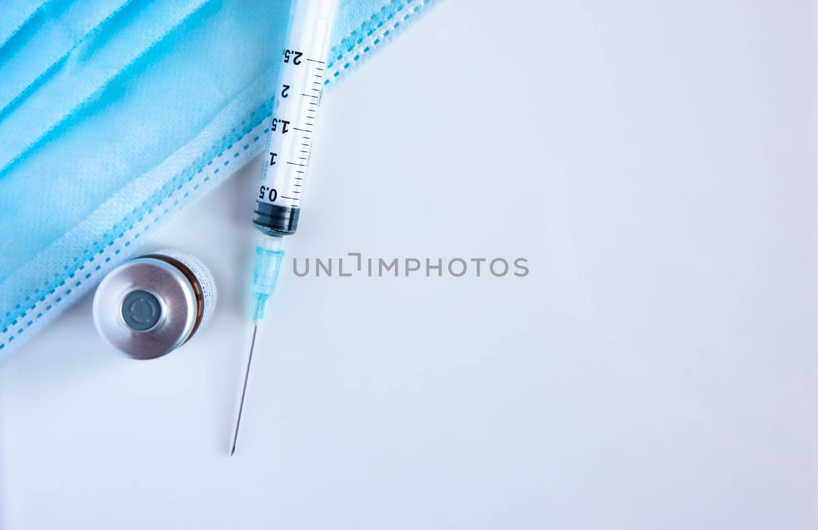A bottle of vaccine with syringe and surgical masks. by maramade