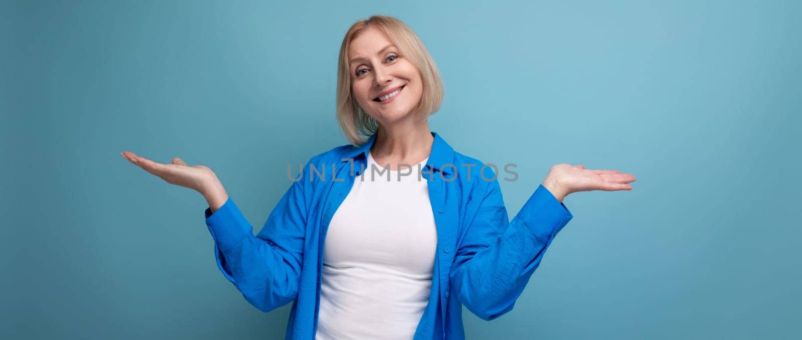 blond mature woman with pleasant smile on studio background.