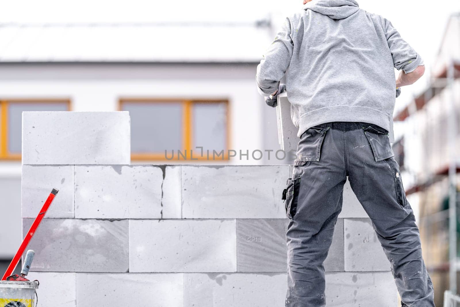 a mason builds the wall of a building from concrete bricks and blocks. High quality photo