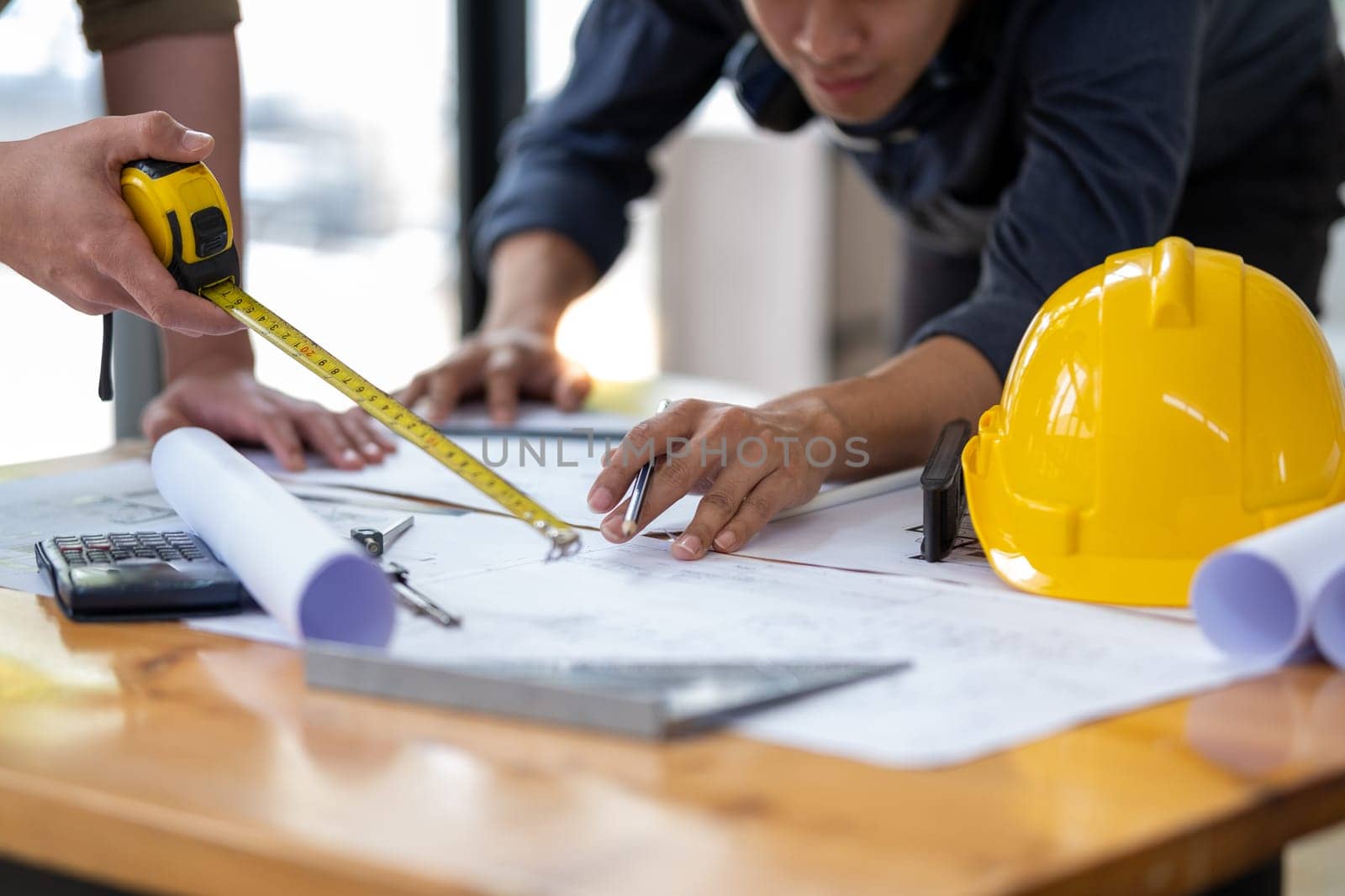 engineer working together draw calculate plan a construction project, engineer people meeting working sharing idea and pointing at a drawings in office. High quality photo