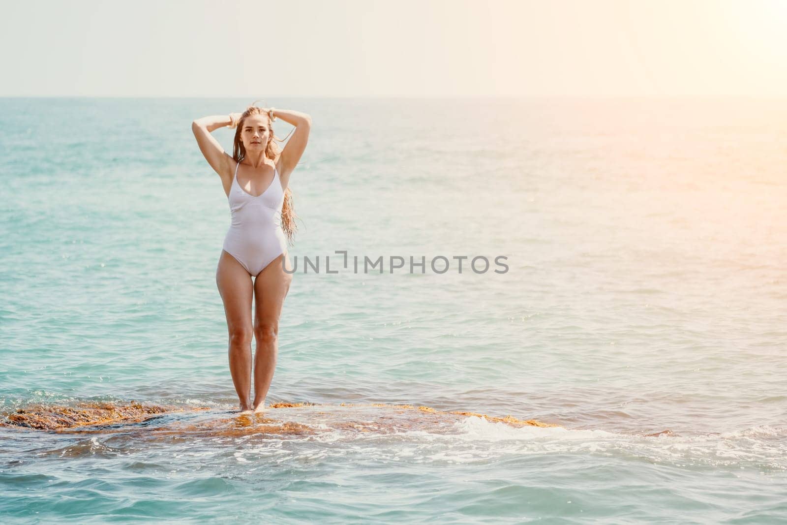 Woman sea yoga. Back view of free calm happy satisfied woman with long hair standing on top rock with yoga position against of sky by the sea. Healthy lifestyle outdoors in nature, fitness concept by panophotograph