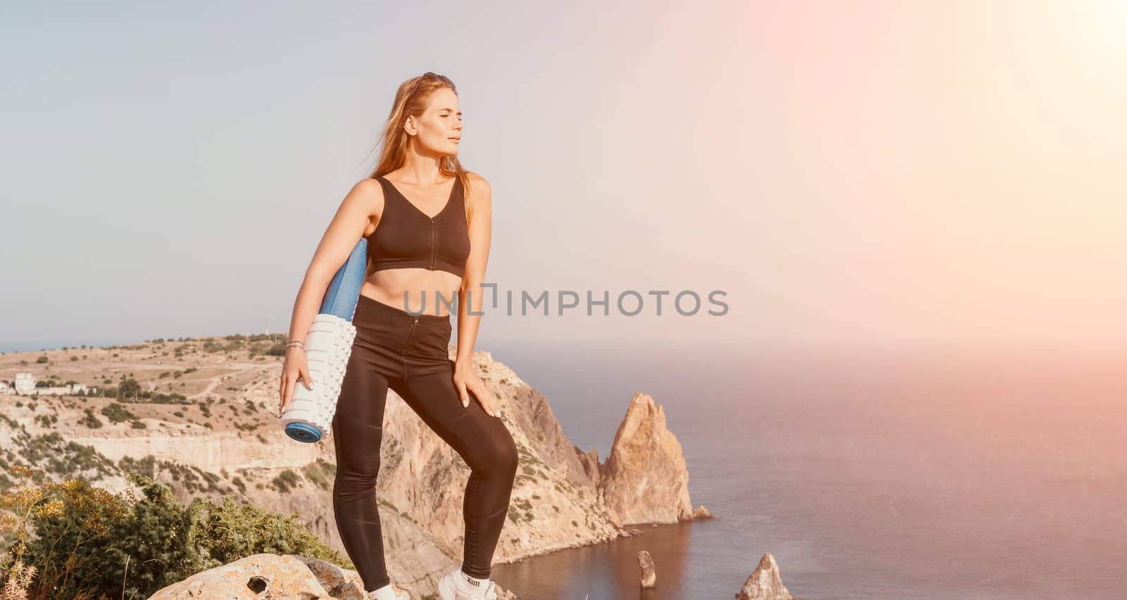 Fitness woman sea. Outdoor workout on yoga mat in park near to ocean beach. Female fitness pilates yoga routine concept. Healthy lifestyle. Happy fit woman exercising with rubber band in park.