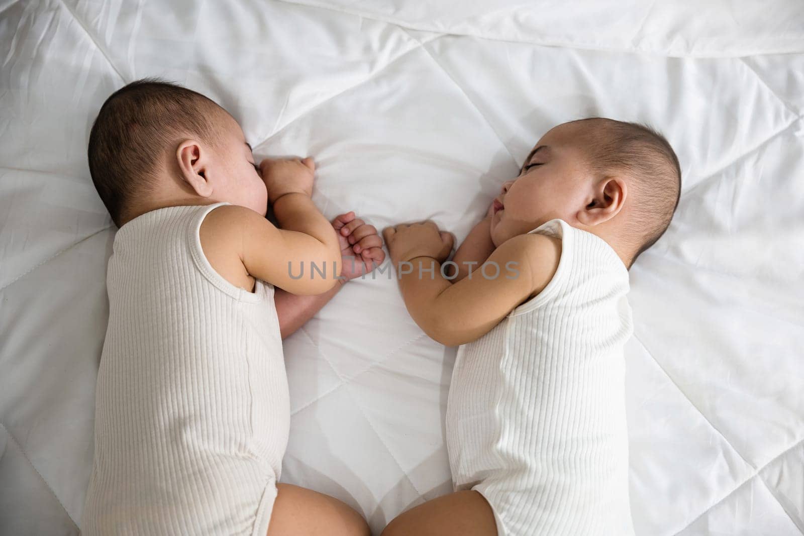 Happy childhood, Sleeping newborn identical boy twins on the bed on bedroom, Asian two adorable twin babies boy, family people infant