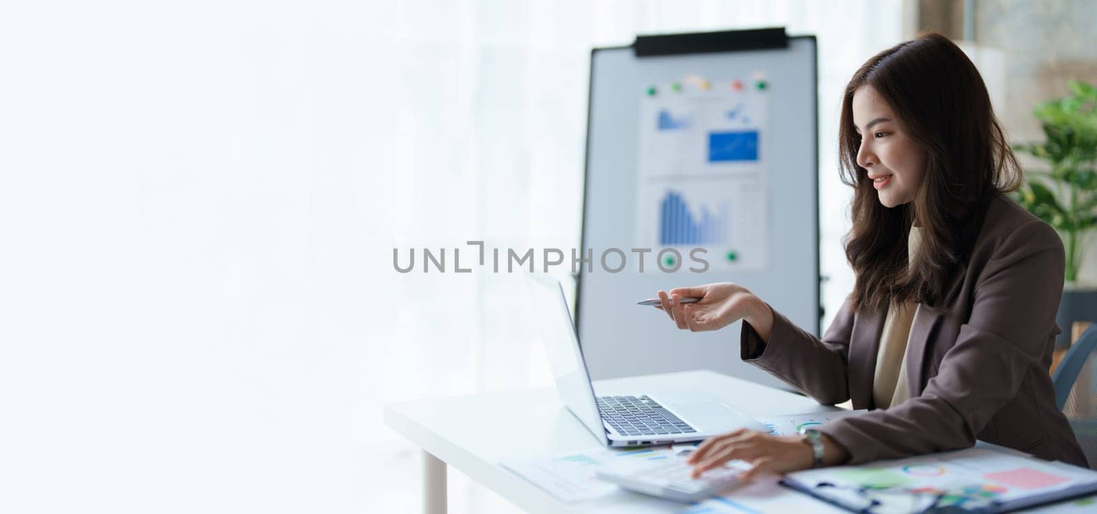 Beautiful young teen asian business woman meeting at on computer laptop with planning working on financial document, tax, exchange, accounting and Financial advisor. by Manastrong