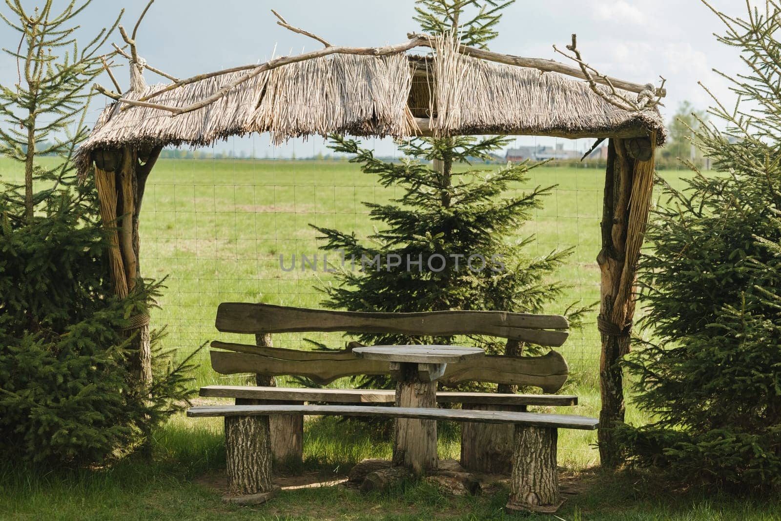 An old wooden gazebo for relaxing in the park. Equipped with wooden tables and benches.