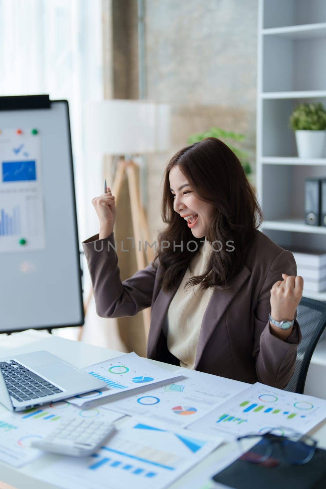 Beautiful young teen asian businesswomen using computer laptop with hands up in winner is gesture, Happy to be successful celebrating achievement success by Manastrong