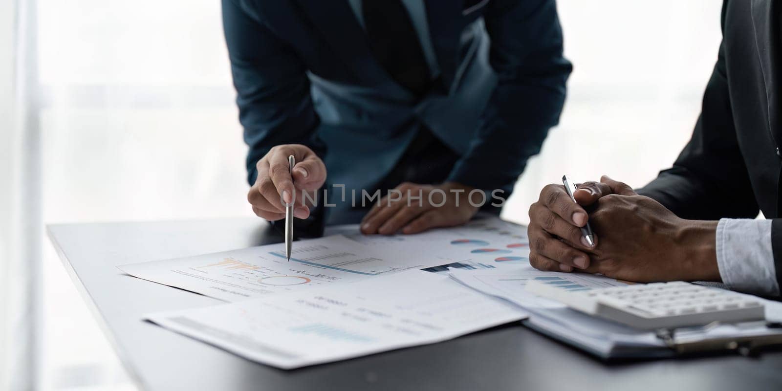 Meeting business team advisor about financial graph chart showing results are analyzing and use calculating with calculator planning strategy.