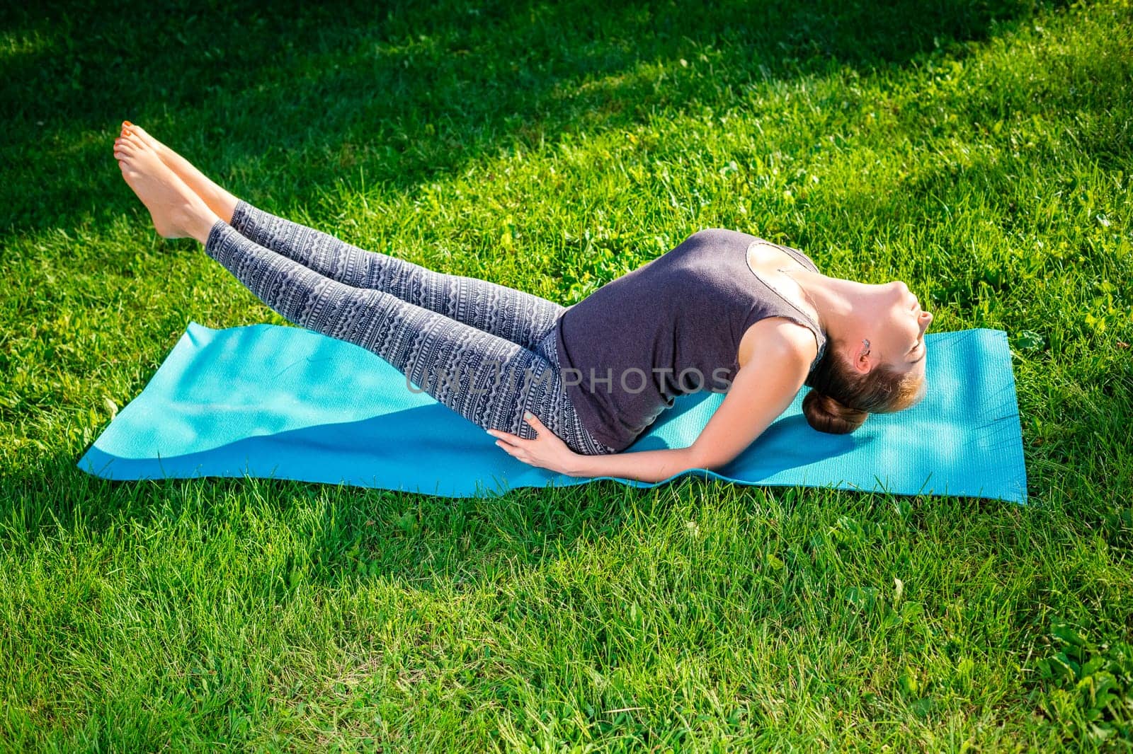 Young fitness woman meditation in a city park.Yoga at sunset in the park. Girl is practicing yoga. Fitness training outdoors. Attractive fitness woman. Workout outdoors. Healthy lifestyle