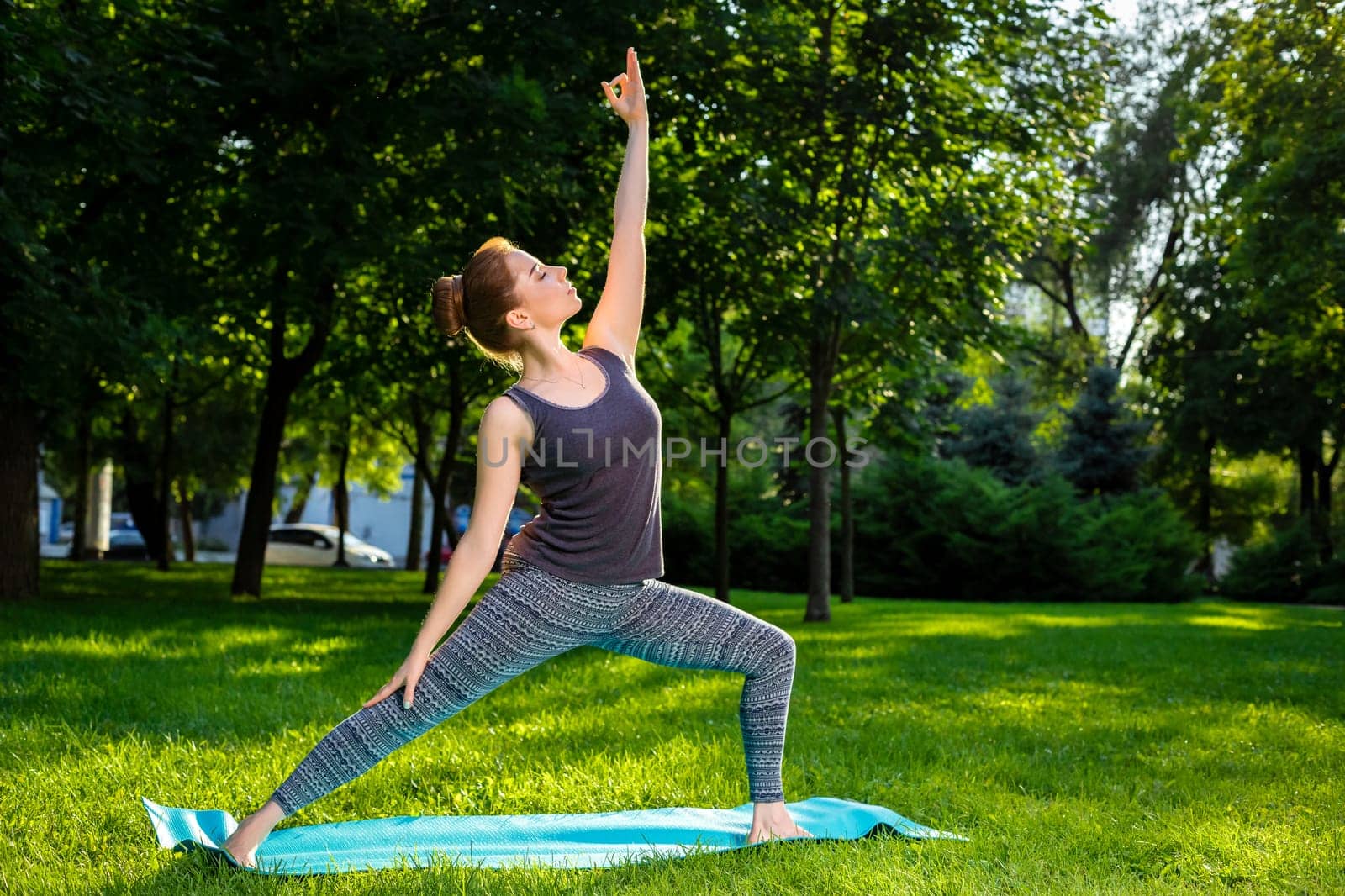 Young fitness woman meditation in a city park.Yoga at sunset in the park. Girl is practicing yoga. Fitness training outdoors. Attractive fitness woman. Workout outdoors. Healthy lifestyle