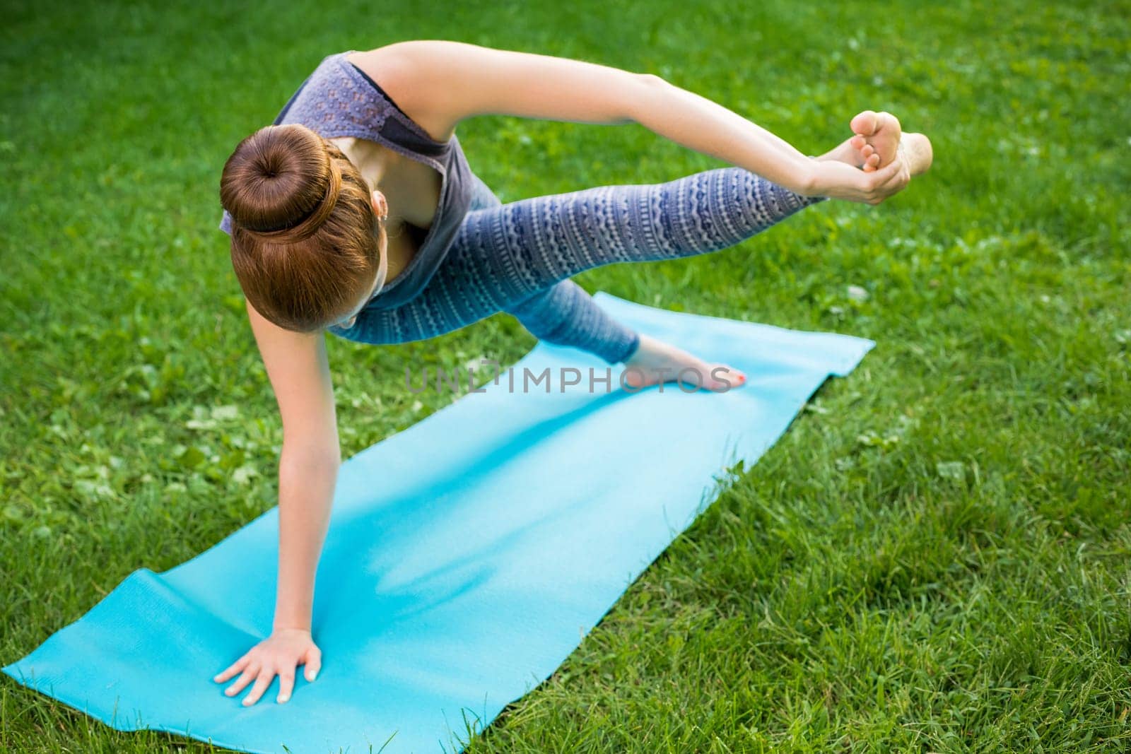 Young fitness woman meditation in a city park.Yoga at sunset in the park. Girl is practicing yoga. Fitness training outdoors. Attractive fitness woman. Workout outdoors. Healthy lifestyle