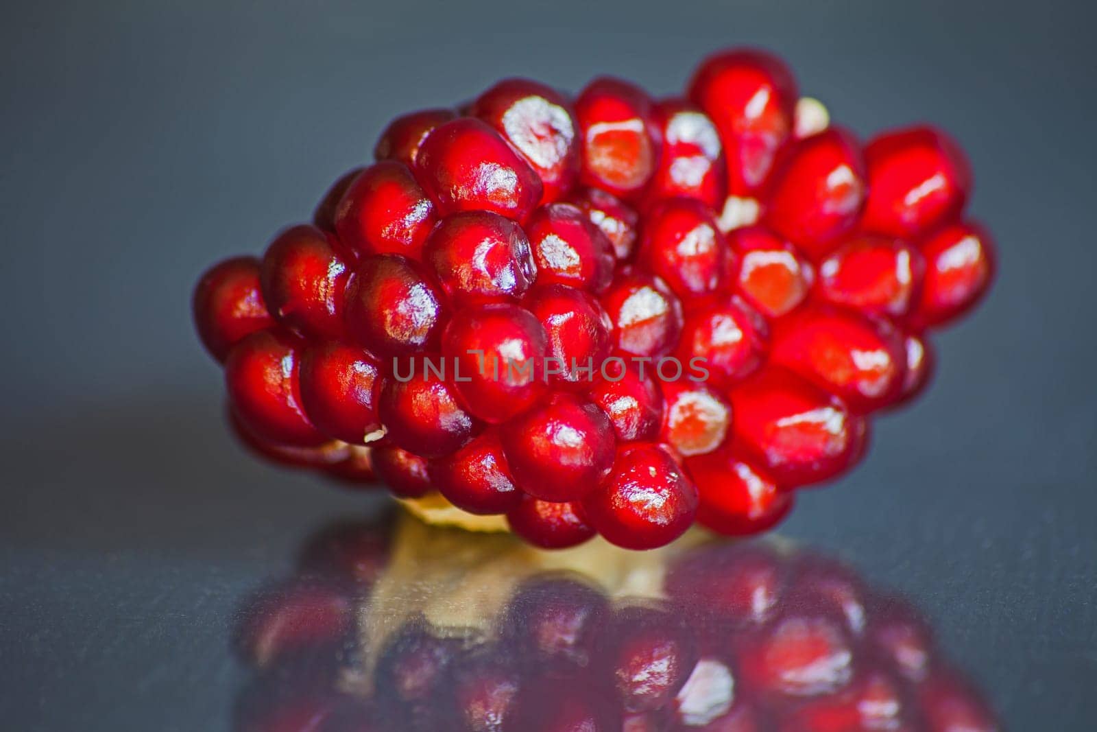 Ripe Pomegranate seeds in the fruit body on a dark blurred background