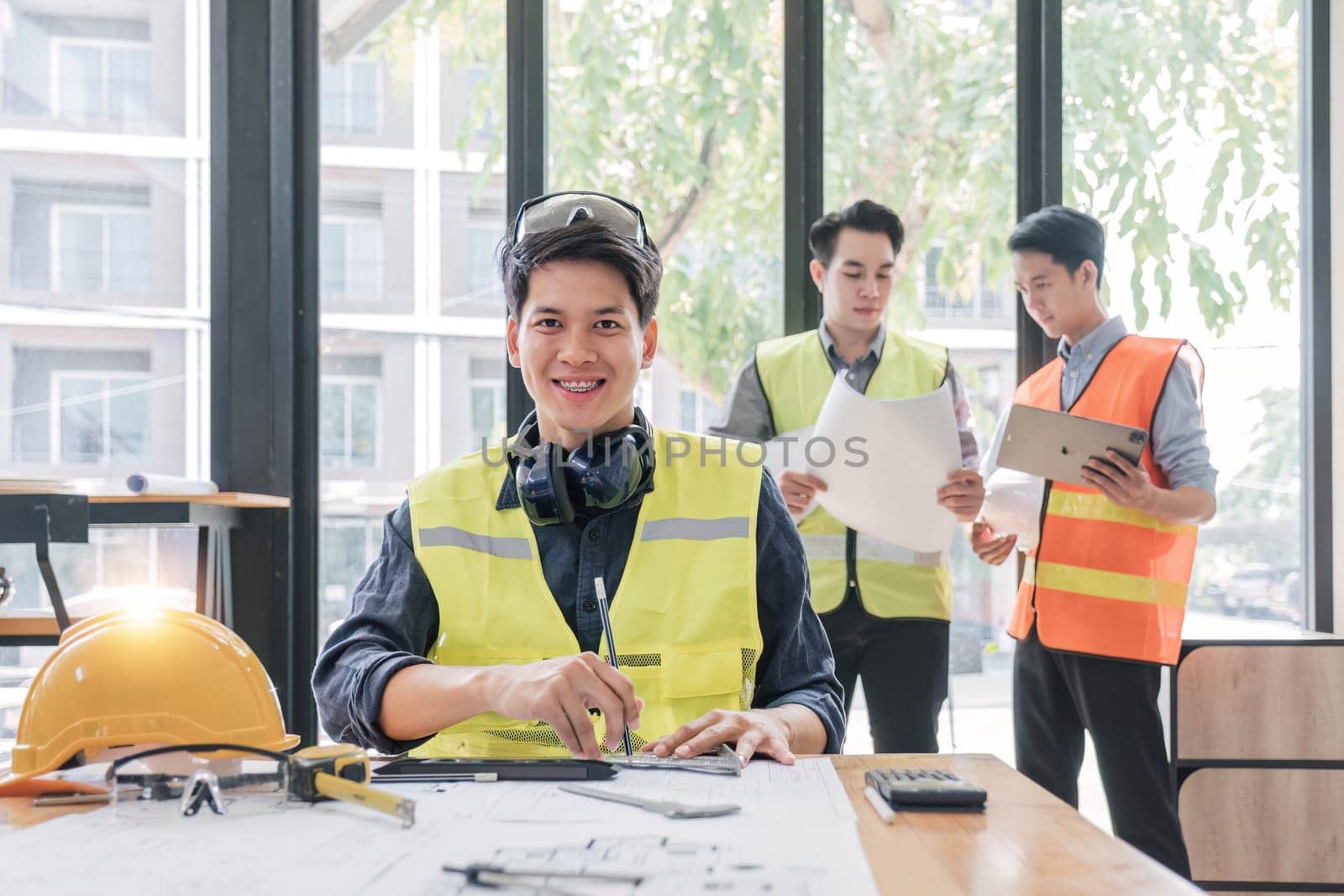 Civil engineer teams meeting working together wear worker helmets hardhat on construction site in modern city. Foreman industry project manager engineer teamwork. Asian industry professional team