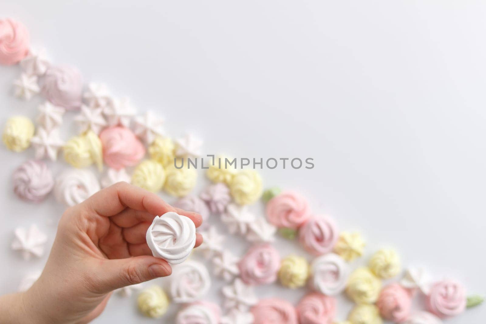 Meringue. Light dessert of whipped egg whites in a female hand .copy space