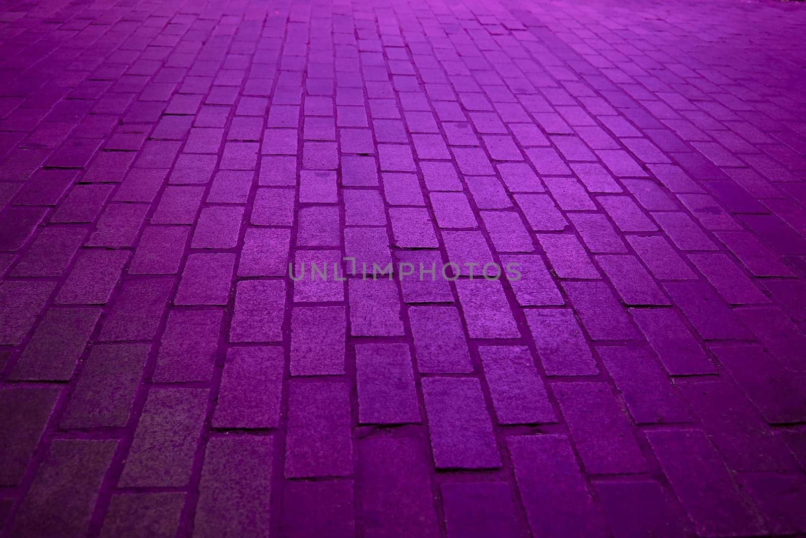 Background. Rectangular cobblestone street with purple light.No one, parallel, perpendicular, perspective depth