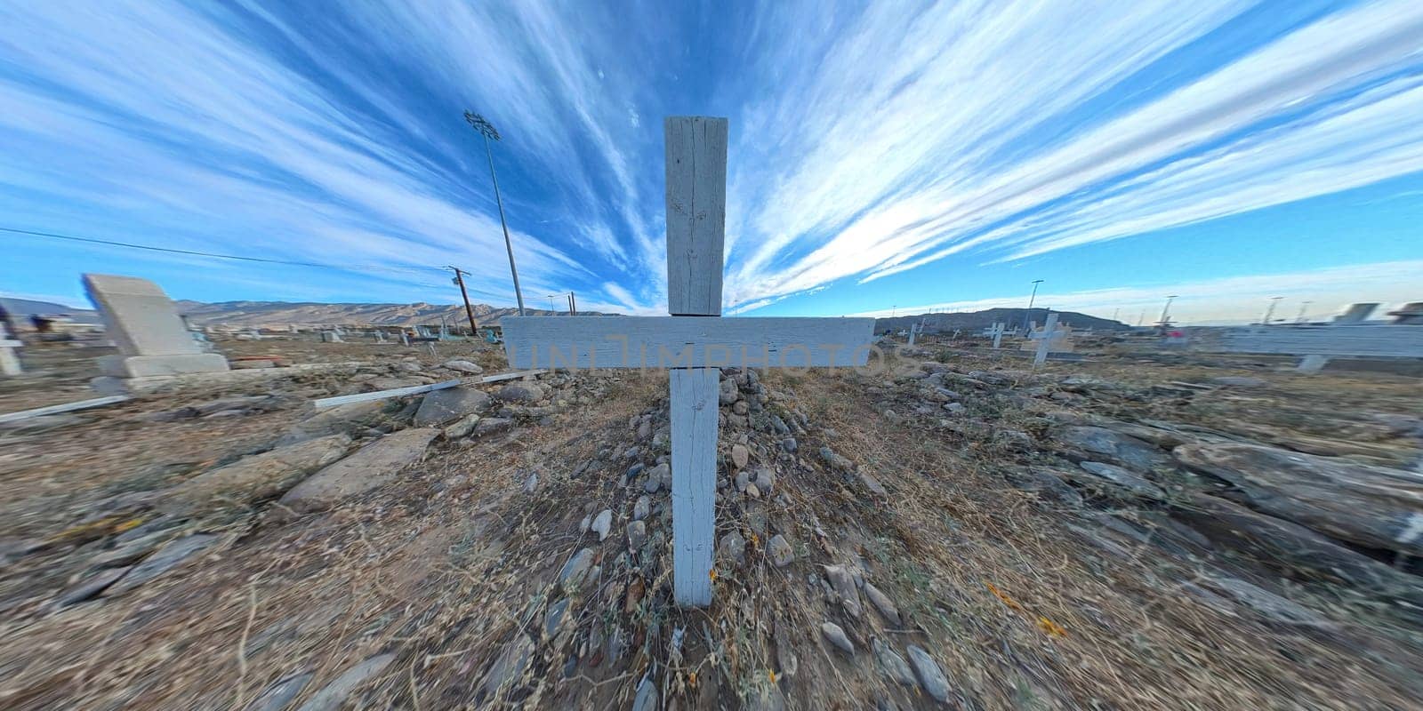 Wooden cross at cemetery with stripped sky background focus to soft focus