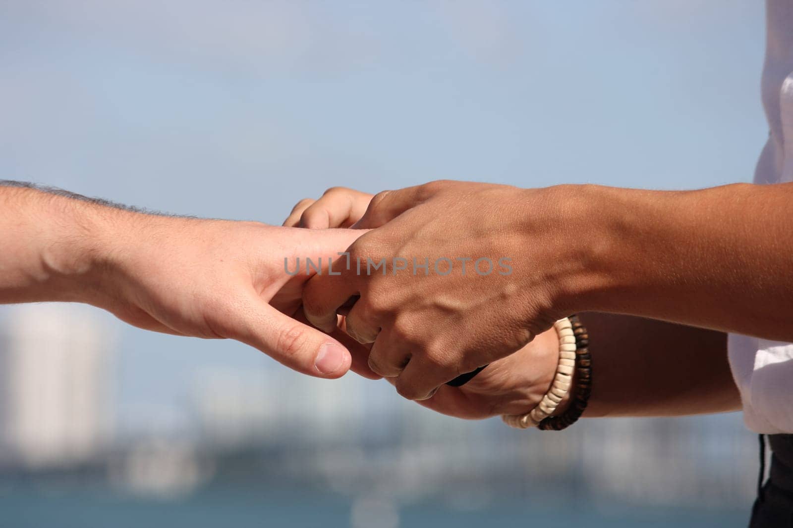 Gay marriage joining hands and putting a ring on his finger, when standing on the beach.