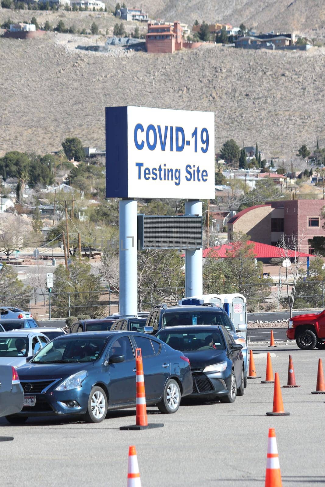 Covid-19 Testing site sign posted outside. Cars waiting.