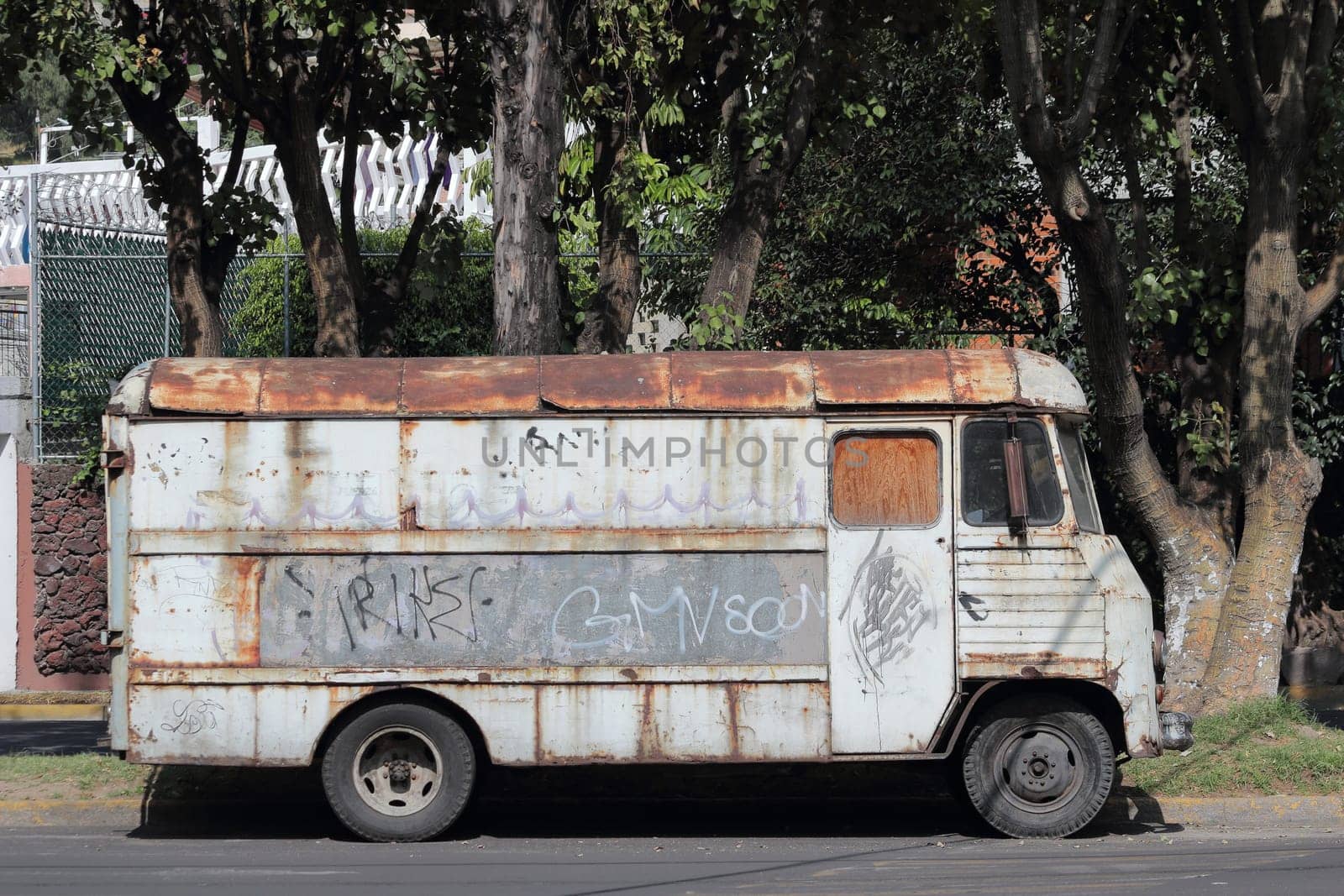 Old rusty bus on the side of the street in Mexico City.