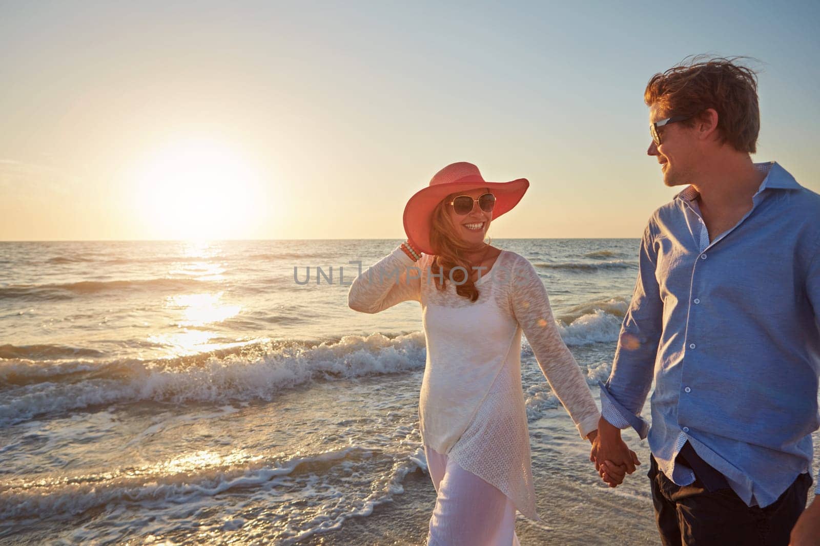 Nothing says romance like a sunset stroll on the beach. a happy couple walking on the beach