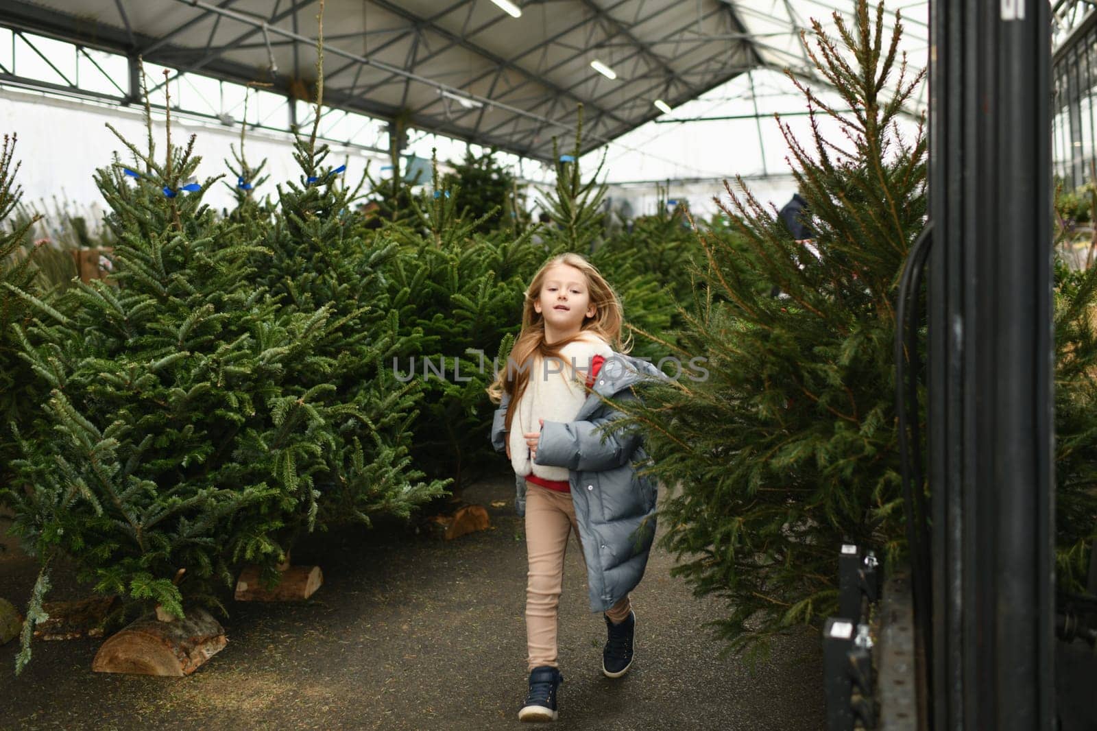 A girl running in a farm of Christmas trees