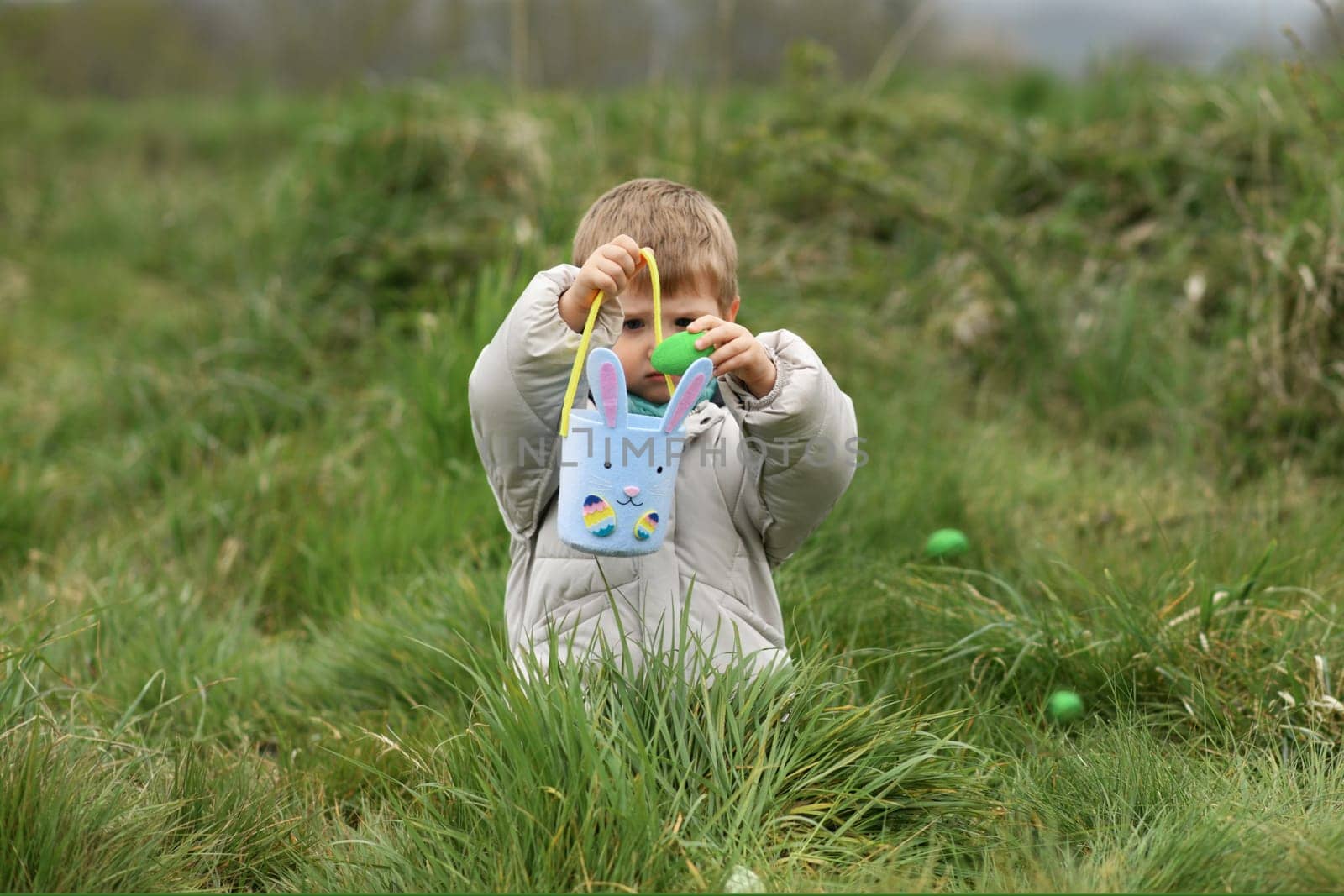 Boy collects the eggs in a basket Easter