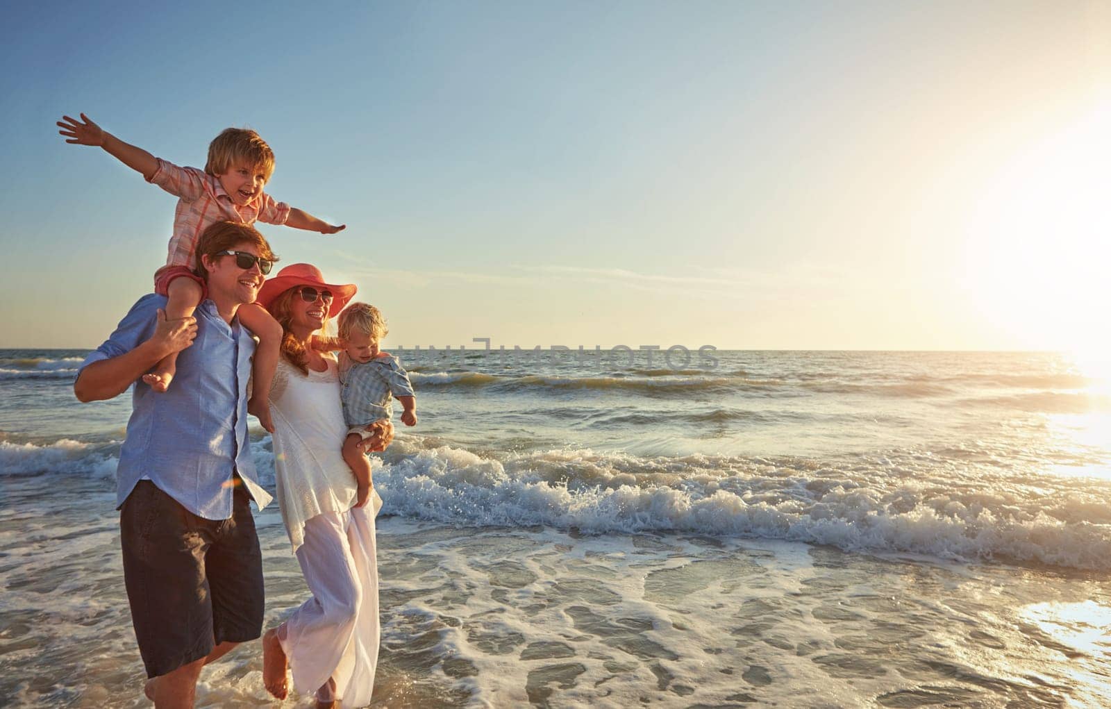 The perfect family vacay. a young family enjoying a day at the beach. by YuriArcurs