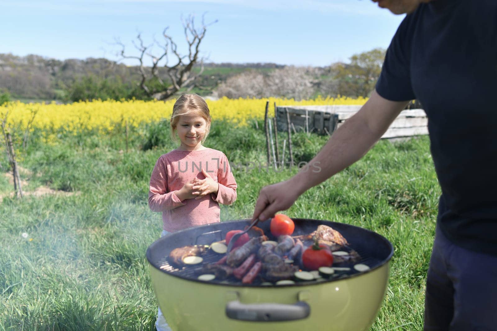 Extended family cooking barbecue in park