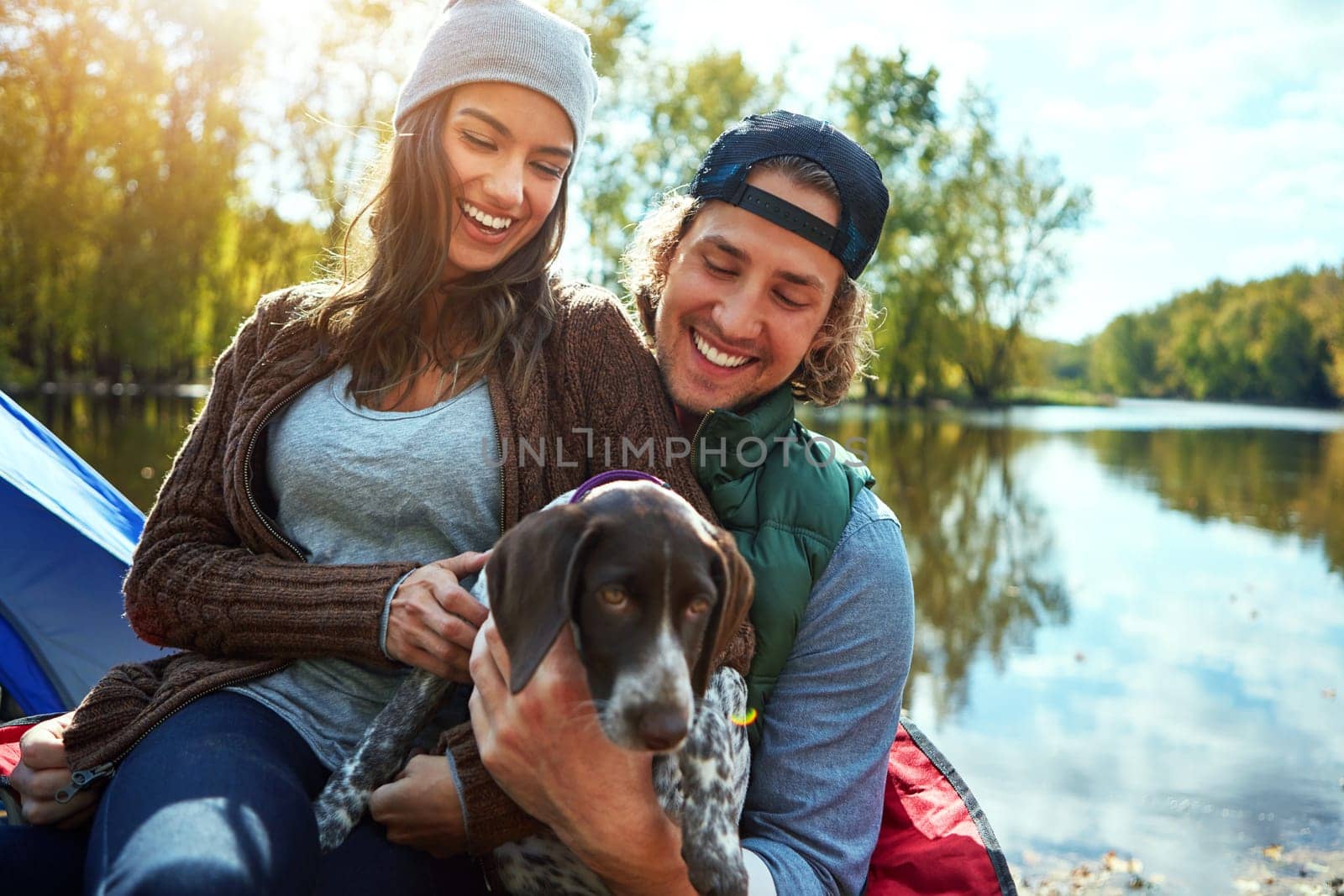 Taking our bonding time outdoors. a loving couple out camping with their dog. by YuriArcurs