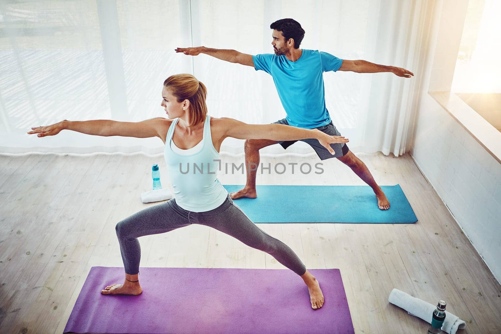 Yoga brings people together through movement. a couple practising yoga at home