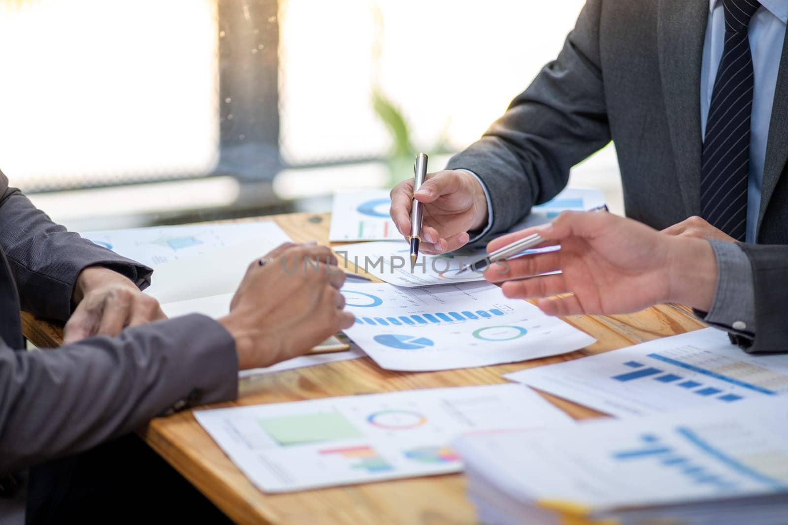 business people meeting analysis teamwork share idea cost graph on desk in office, closed up young business talking discussion calculate at conference. High quality photo